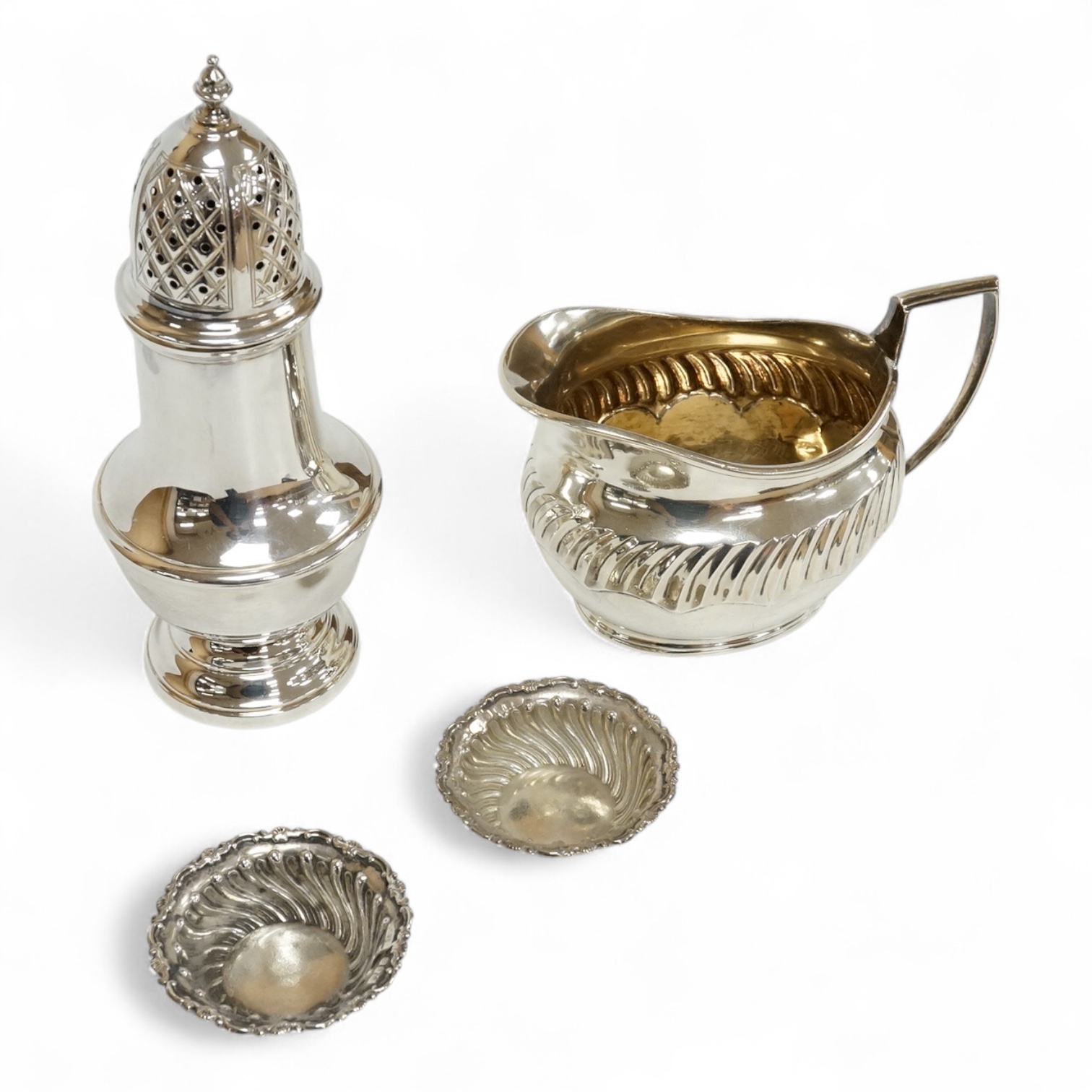 A 1970's silver sugar castor by SCR Ltd, London, 1973, 14.7cm, together with a small silver milk jug and a pair of late Victorian small silver dishes, Miller Brothers, Birmingham, 1899.